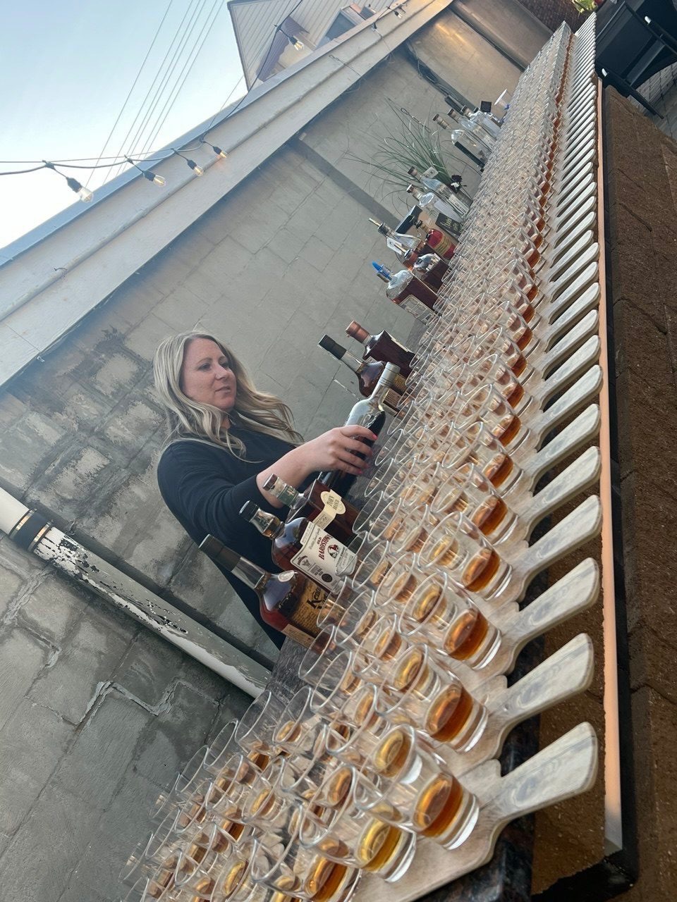 Dozens of bourbon glasses lined up on the patio for a tasting flight