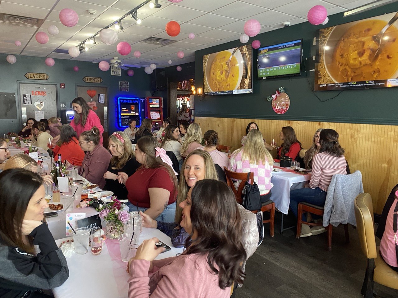 Packed back room decorated in pink for a Galentines lunch