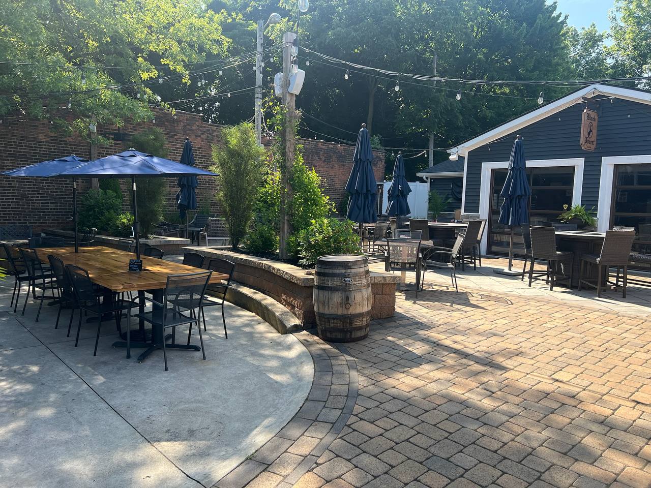Back patio on a quiet sunny afternoon with umbrellas and a bourbon barrel