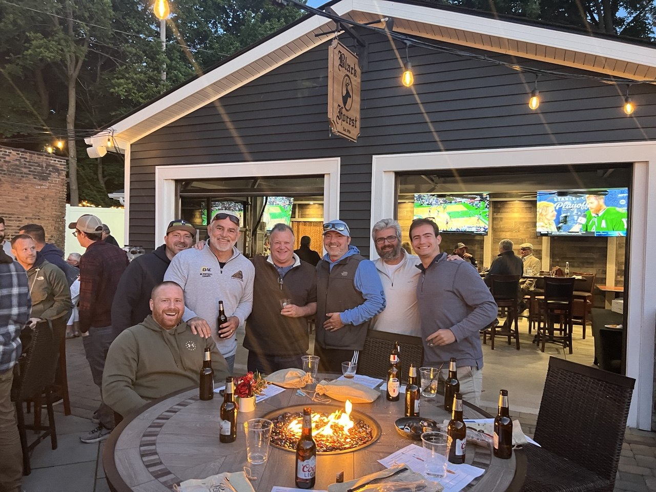 Group of guys around the firepit on the patio at night